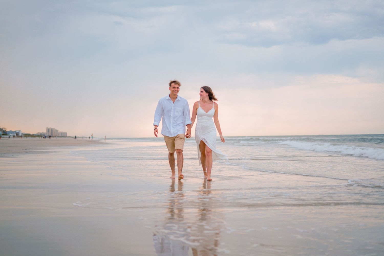 beautiful, well edited image of a couple running along the beach at sunset