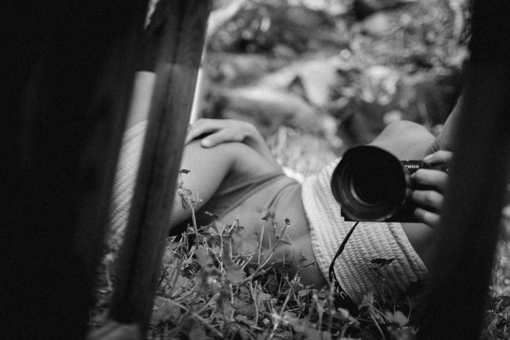 Artistic black and white photo of camera equipment in grass.