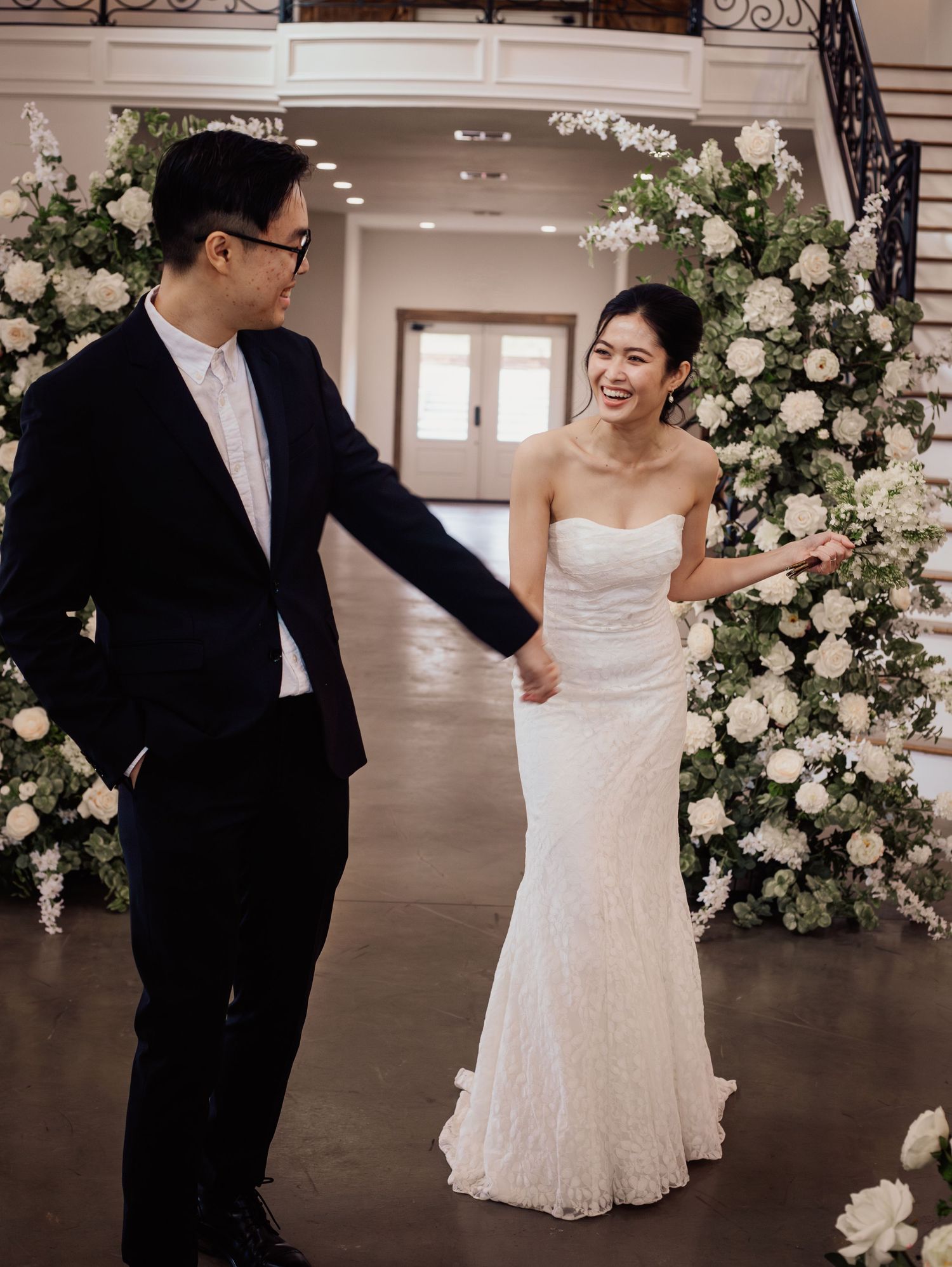 Wedding at Primrose Hill with ivory dress, sage colored flowers and arches, and groom in royal blue suit.