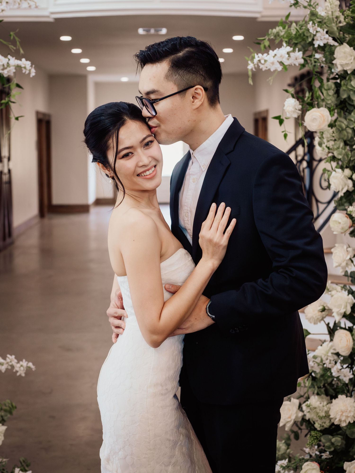 Wedding at Primrose Hill with ivory dress, sage colored flowers and arches, and groom in royal blue suit.
