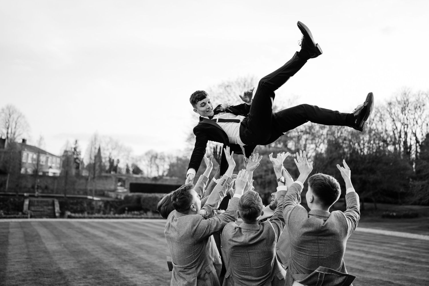 Energetic and fun-loving West Midlands wedding photographer Charlie Nova joyfully thrown in the air