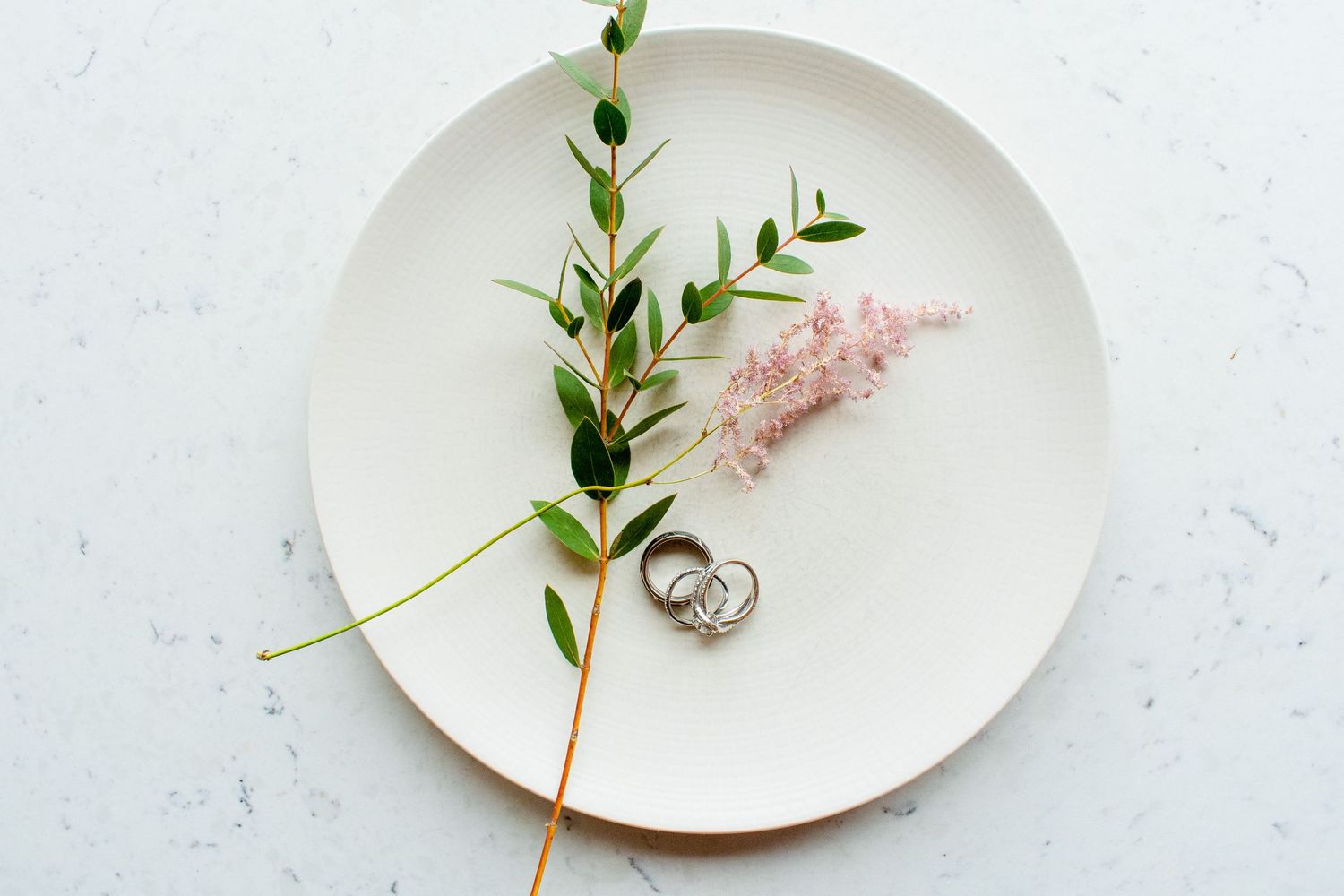 beautiful details photos of rings and florals wedding on a plate