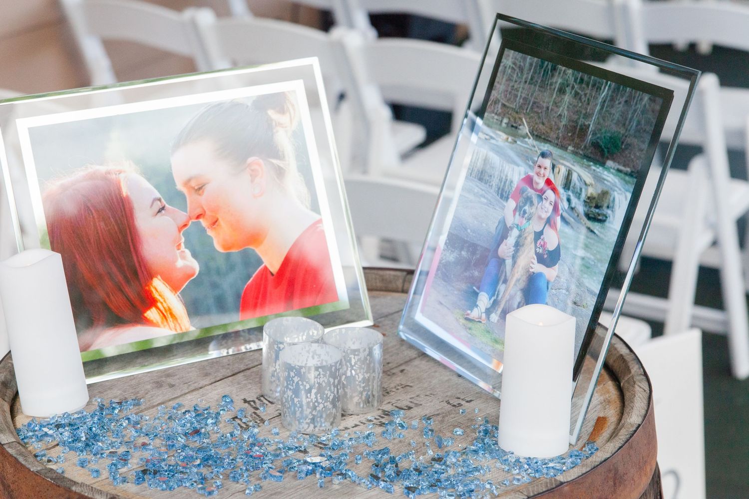 Wedding reception decor featuring blue crystals and white candles in glass holders.