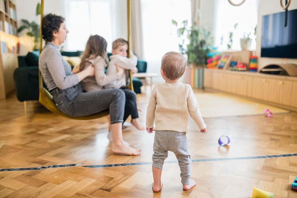 Casual family scene in modern living room with ball and indoor exercise equipment.