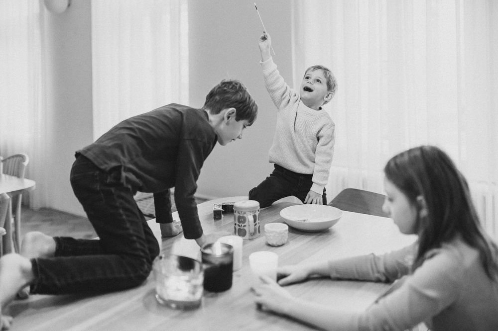Black and white image capturing an energetic mealtime moment with animated gestures.