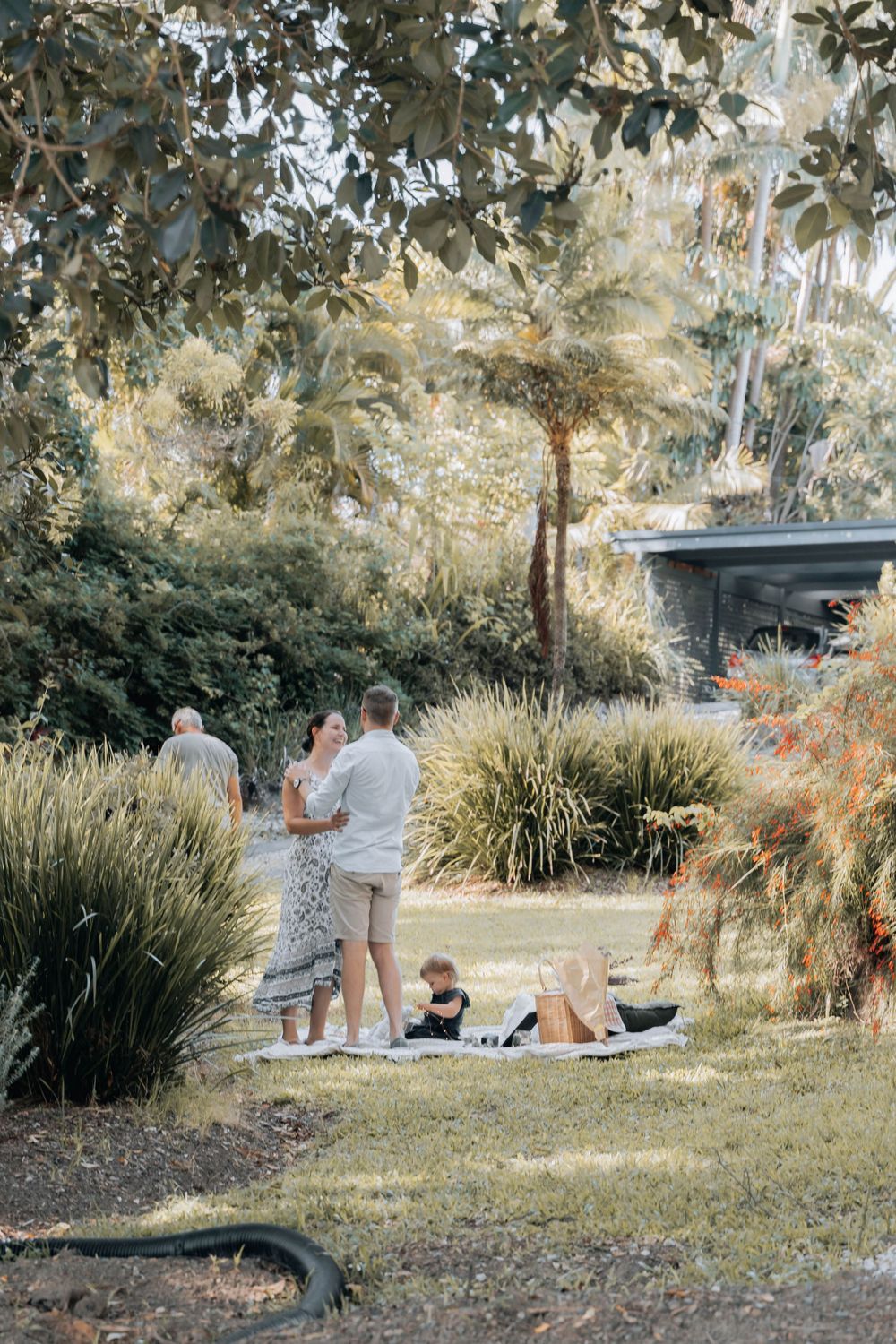 A peaceful garden scene with people enjoying a picnic among ornamental grasses.