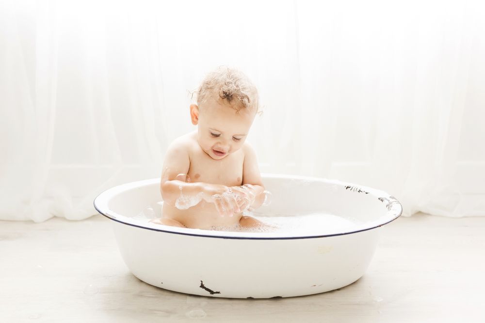 baby in bubble bath vintage tub backlit sheer curtains light and airy