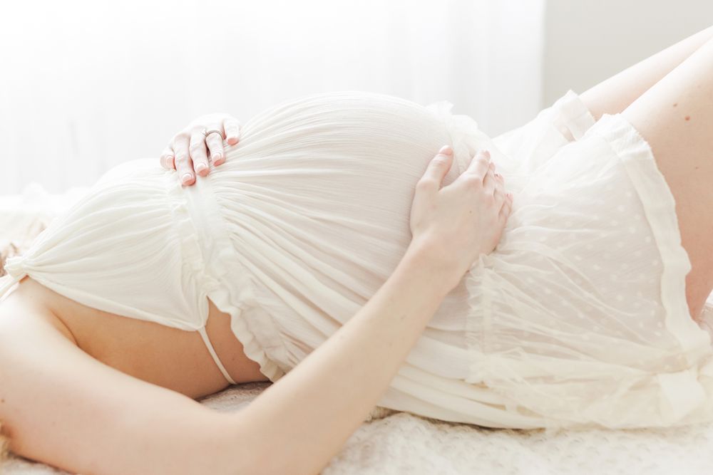 Lesley Moody Photography Wichita KS maternity mother laying showing pregnant belly backlit soft light