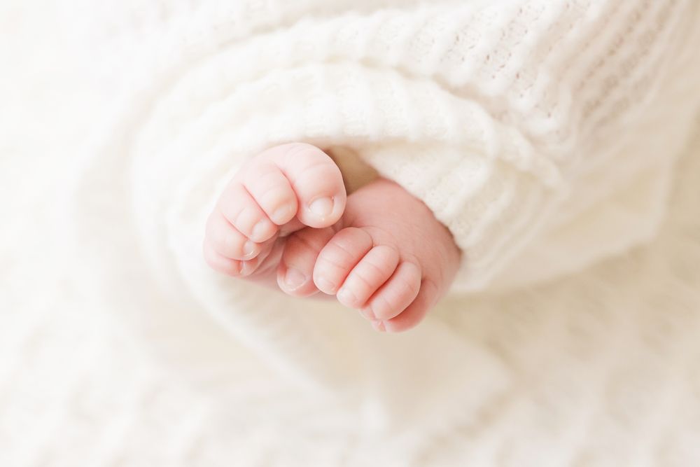 Lesley Moody Photography Wichita KS newborn baby toes wrapped in cream blanket