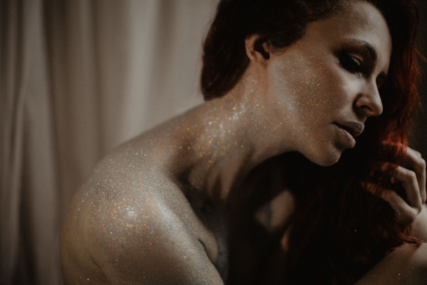 Atmospheric portrait with dramatic lighting and water droplets on skin.