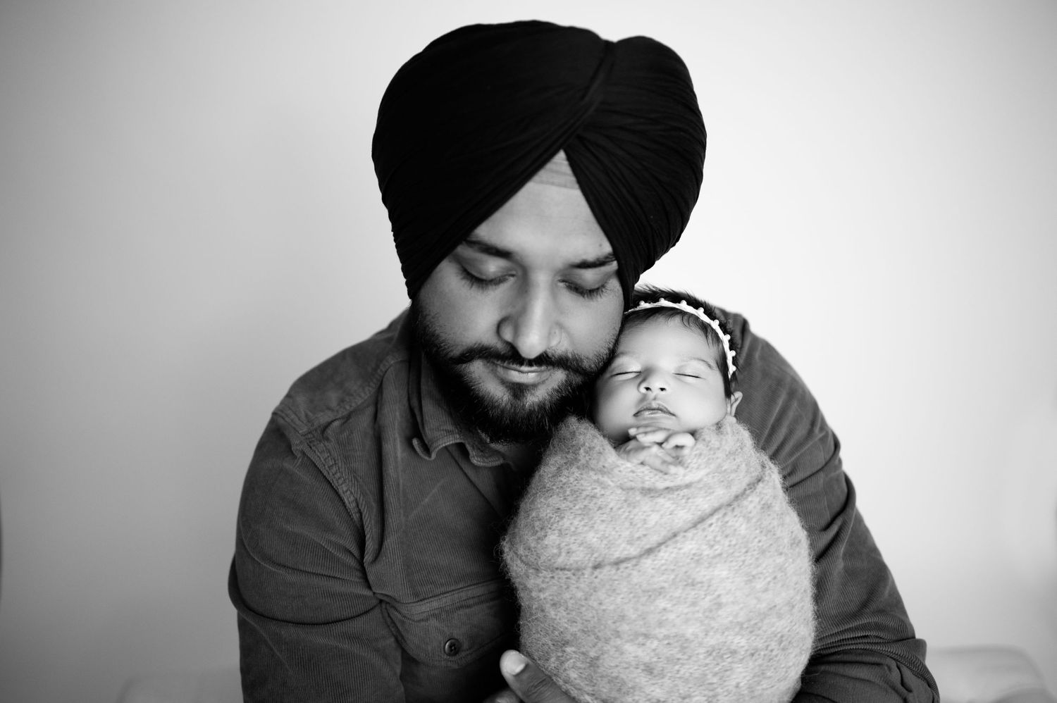 A series of gentle black and white portraits showing tender moments between parent and baby.