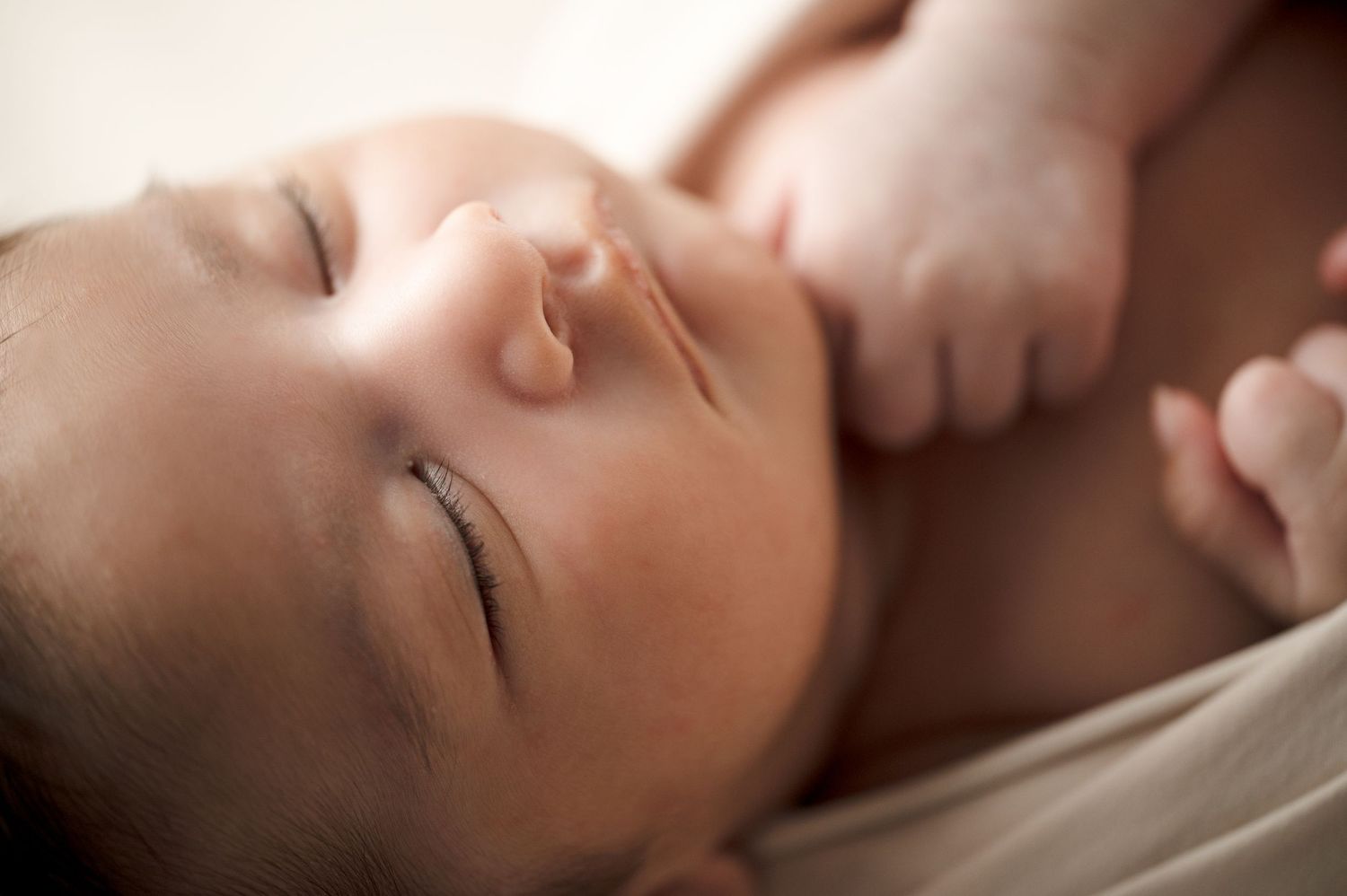 Close-up portrait of sleeping newborn with soft natural lighting.