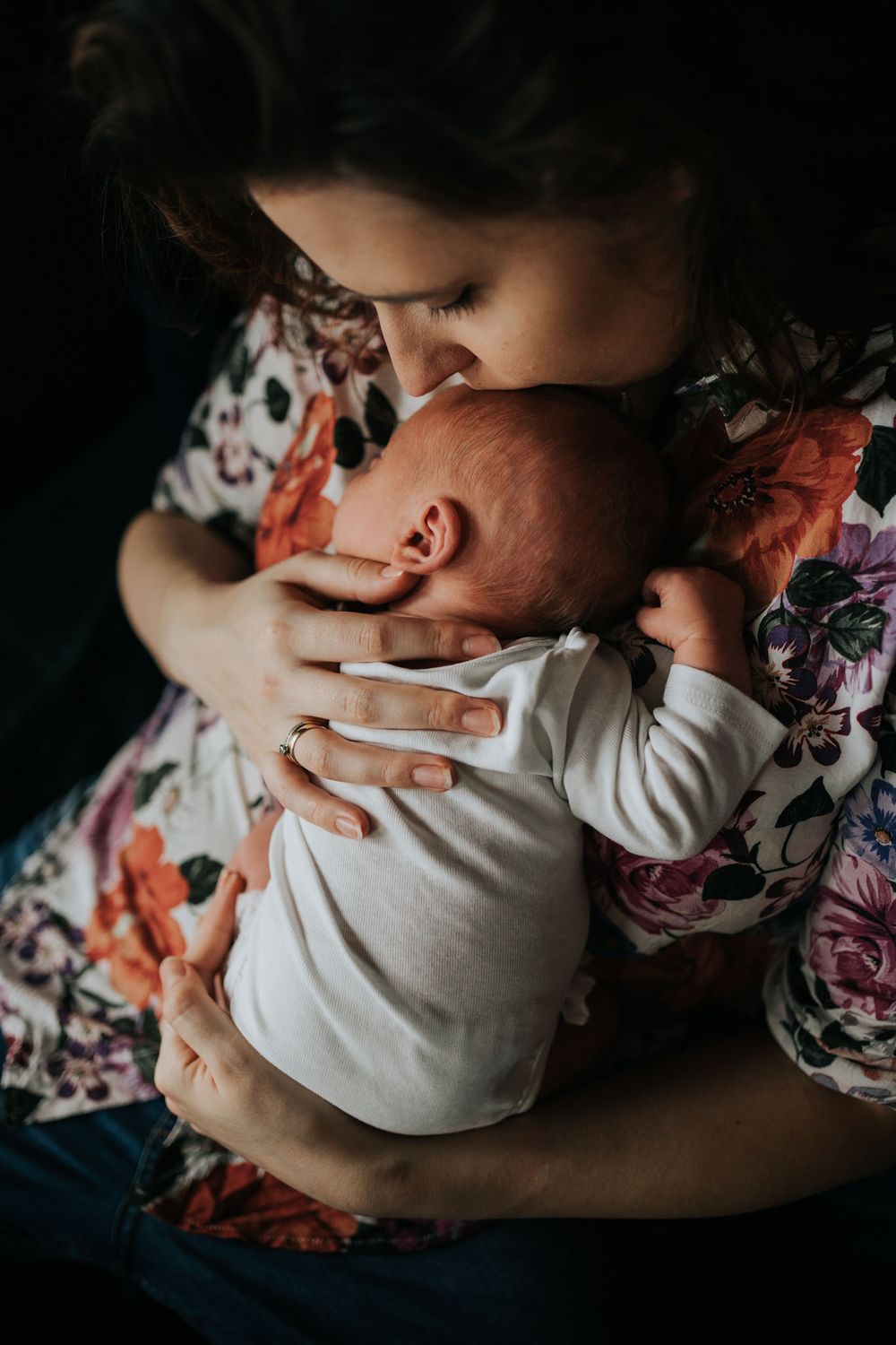 mama czule całuje noworodka - sesja noworodkowa Kraków