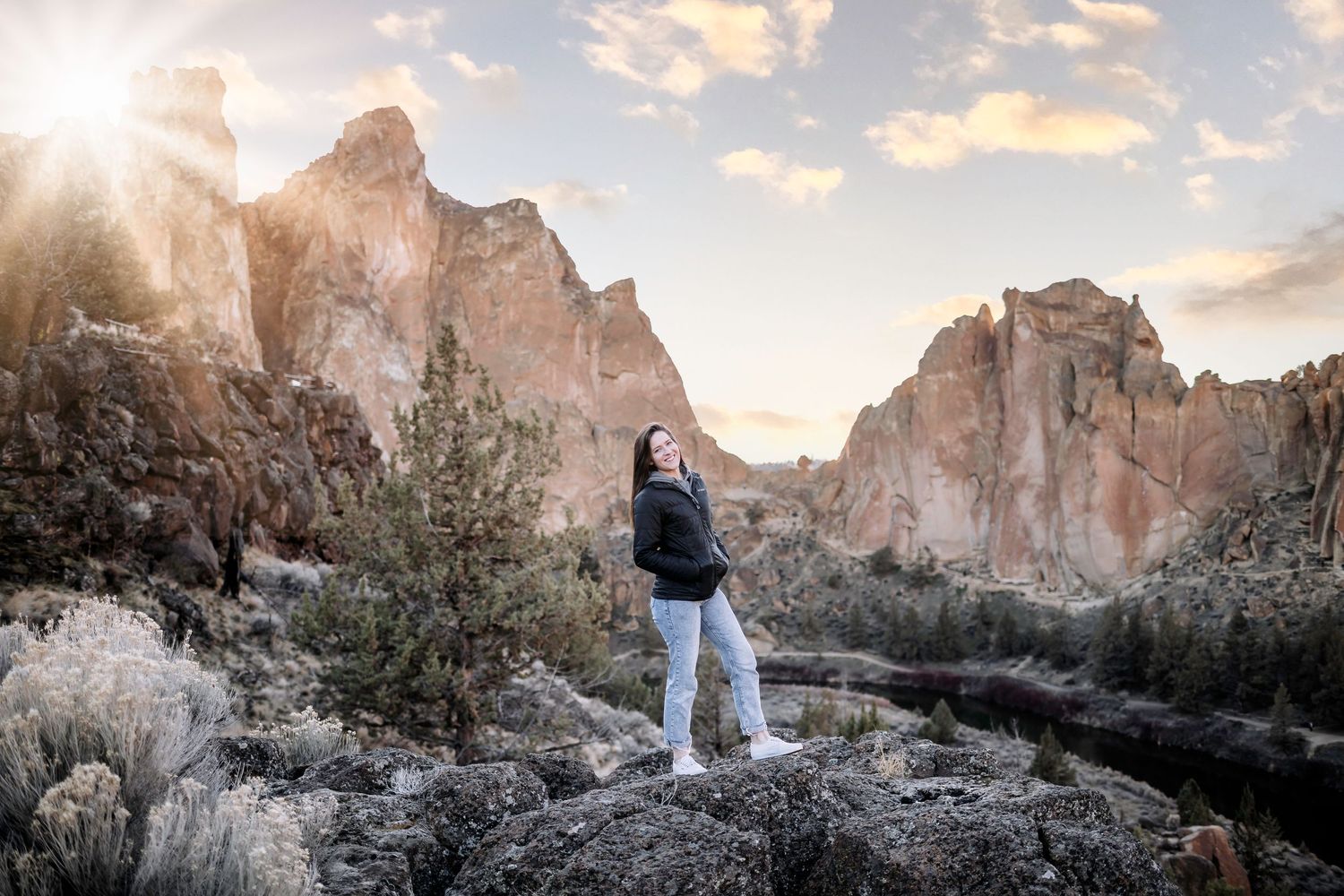 Scenic mountain landscape at sunset with dramatic rock formations and golden light.