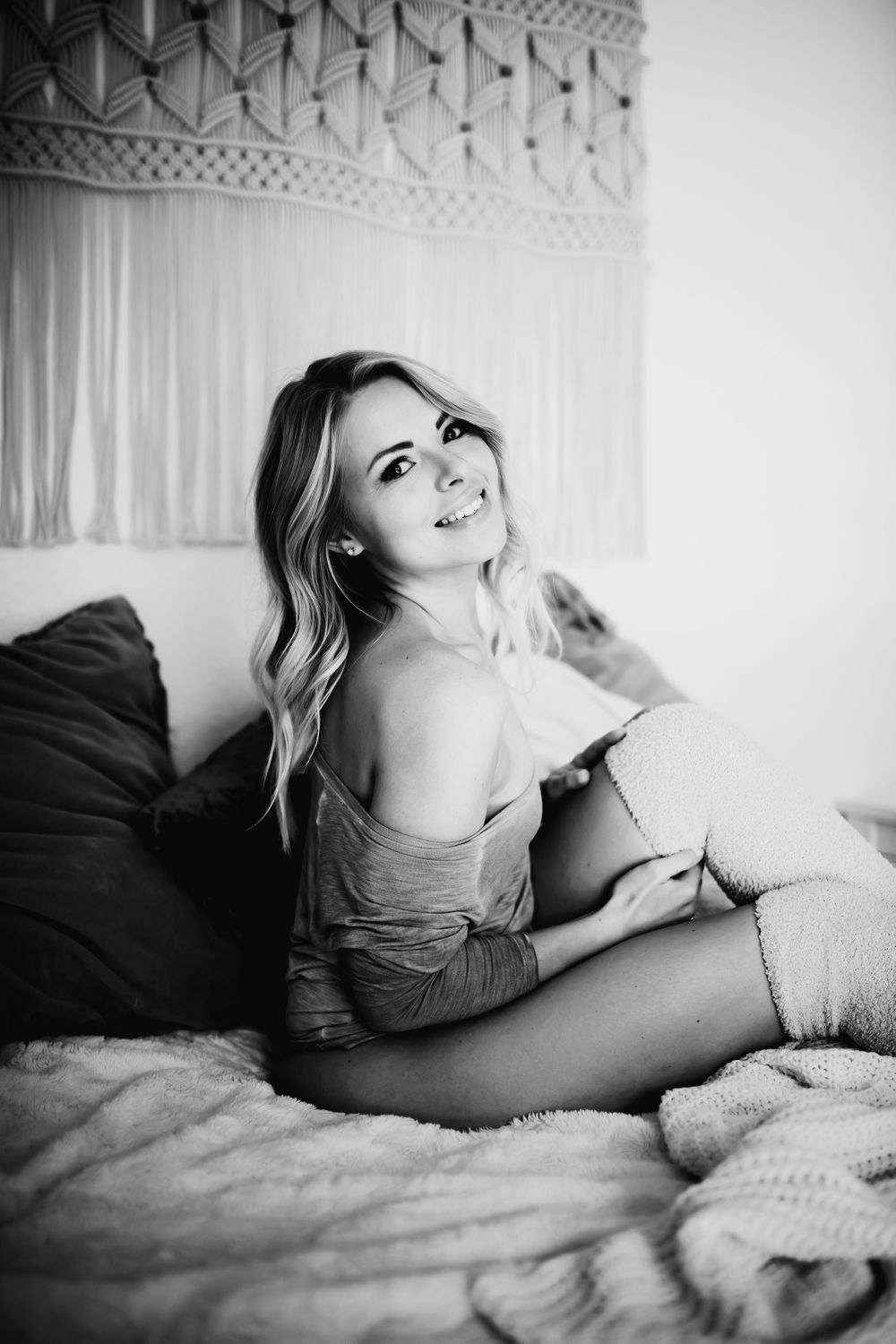 Intimate boudoir photography featuring soft natural light and macrame wall hanging.
