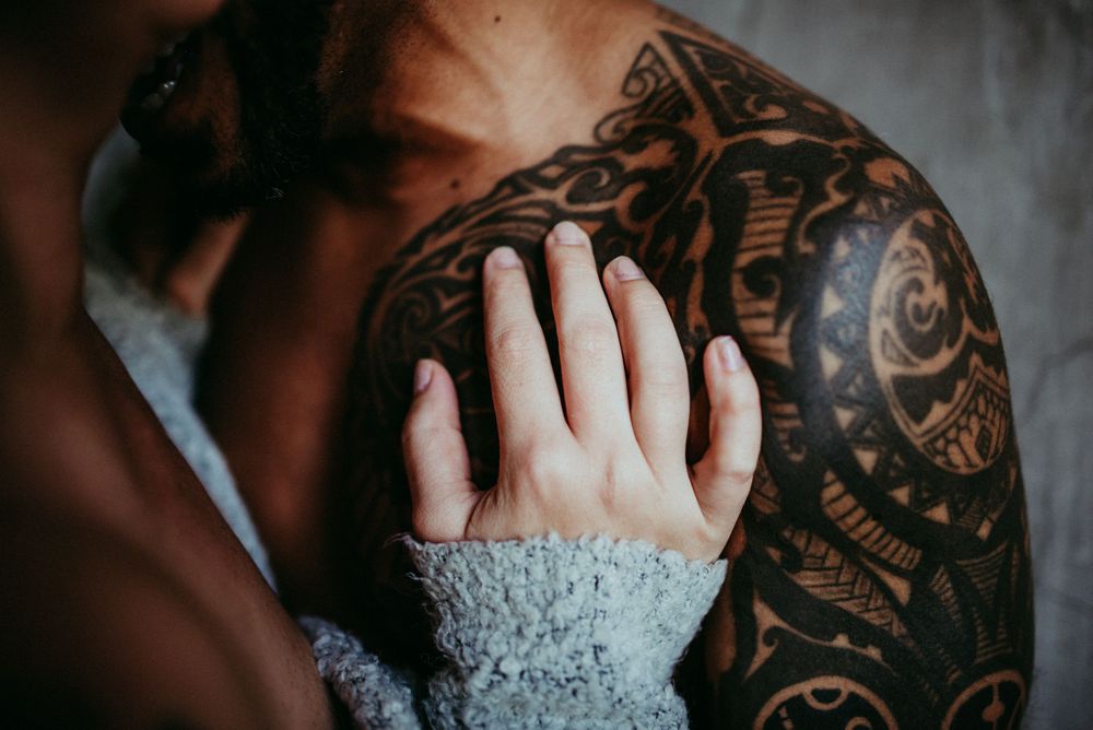 Close-up detail shot of hand touching intricate tattoo artwork.