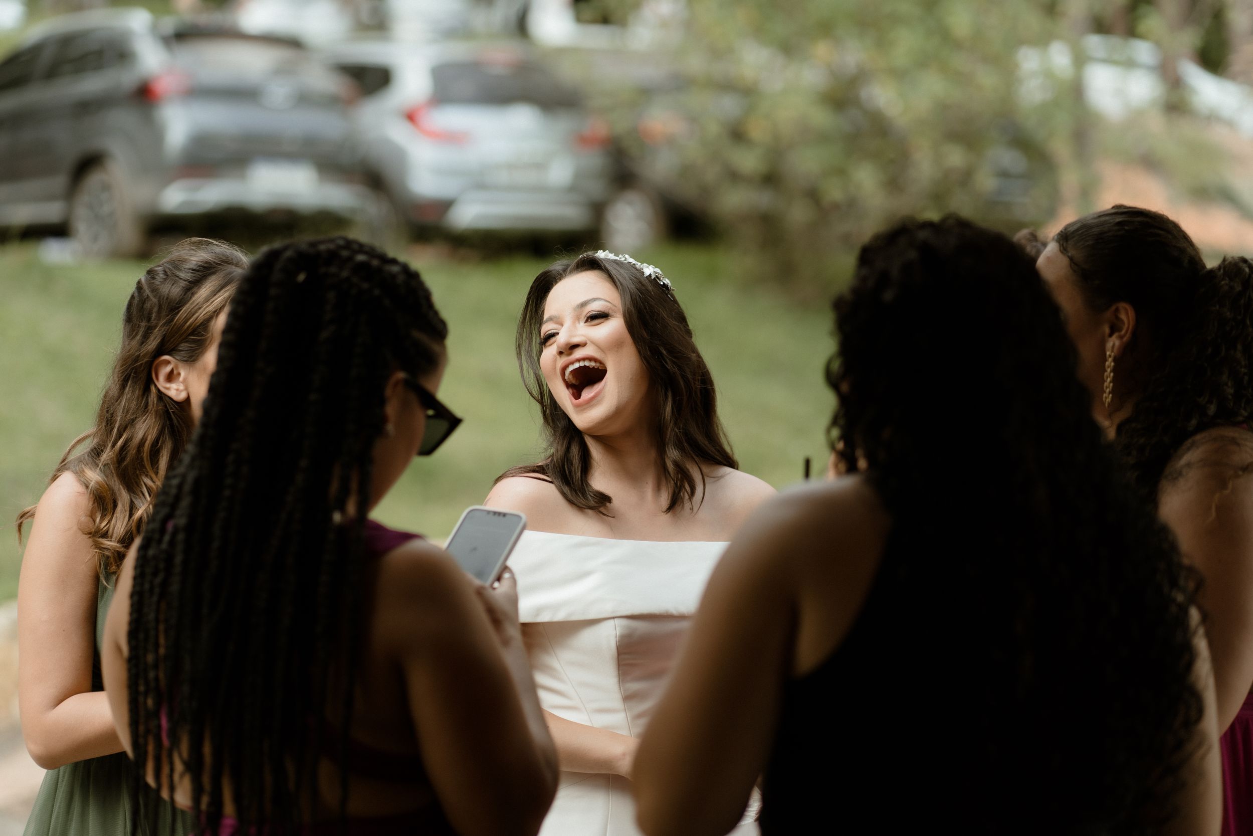 Wedding guests laugh joyfully during outdoor celebration.