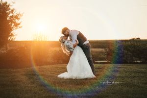 A romantic scene captured during golden hour at sunset in a countryside setting with a beautiful lens flare effect.