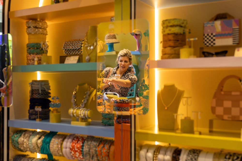 Illuminated yellow retail shelving display with various packaged items.