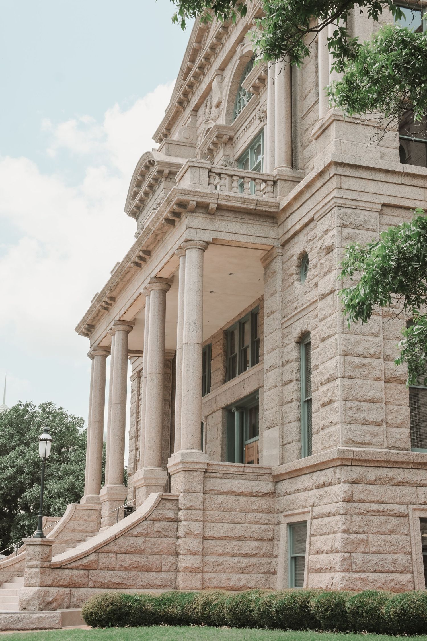 Exterior view of a grand historic courthouse building with stone columns and architectural details.