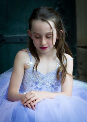 A young dancer in a lavender tulle dress looks down thoughtfully in an artistic portrait. Dance Photographer Batavia Cincinnati Ohio