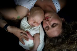 Overhead view of a sleeping infant in white clothing being cradled. Newborn photographer Batavia Cincinnati Ohio