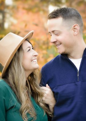 Romantic couple in fall attire sharing intimate moment against autumn foliage. Engageme Family photographer Batavia Cincinnati Ohio