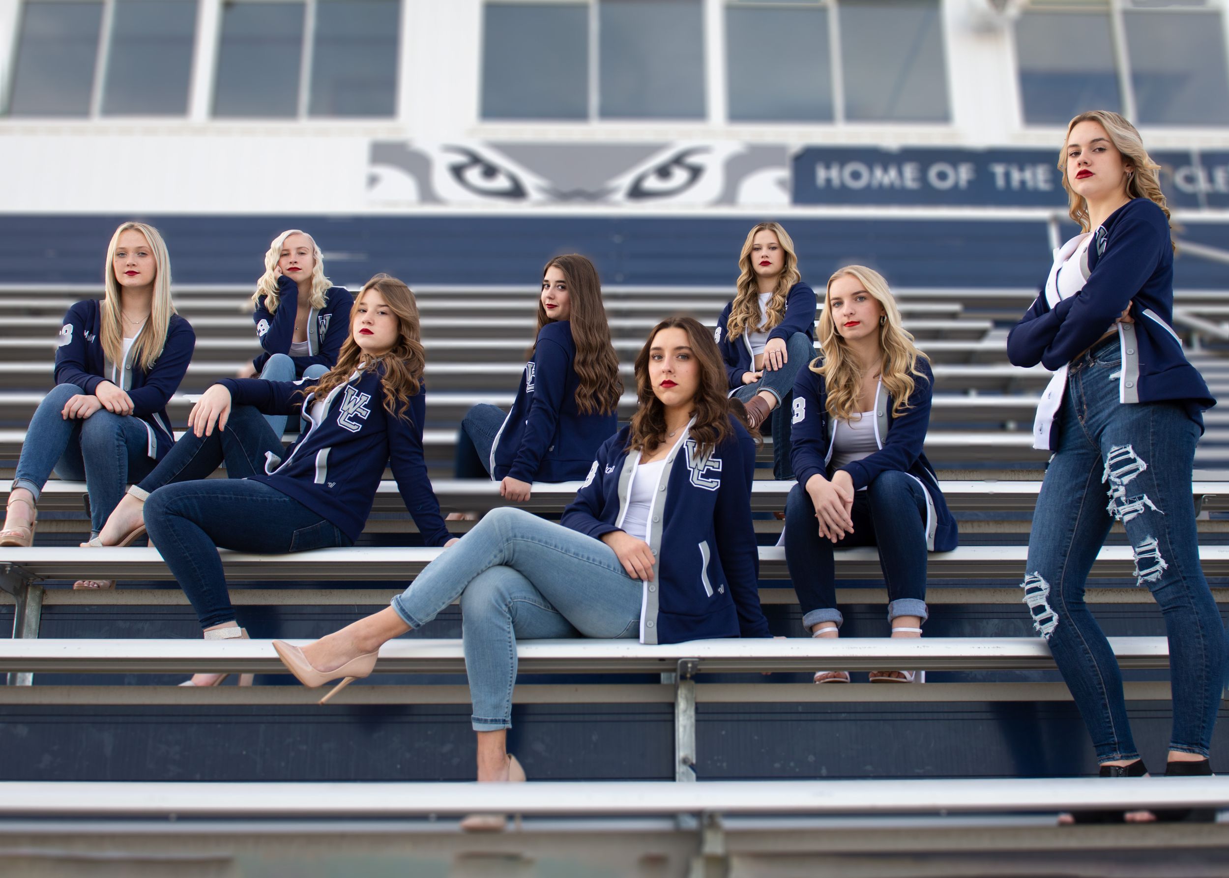 Group of students in matching navy jackets posed on outdoor stadium bleachers. Senior Photographer Batavia Cincinnati Ohio