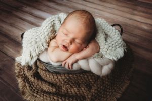 Newborn photo in home with backdrop and bucket. Maryland newborn photographer Annapolis newborn photography studio