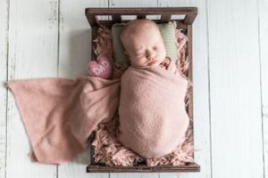 Newborn baby girl photo with props in bed. Annapolis Newborn photography studio