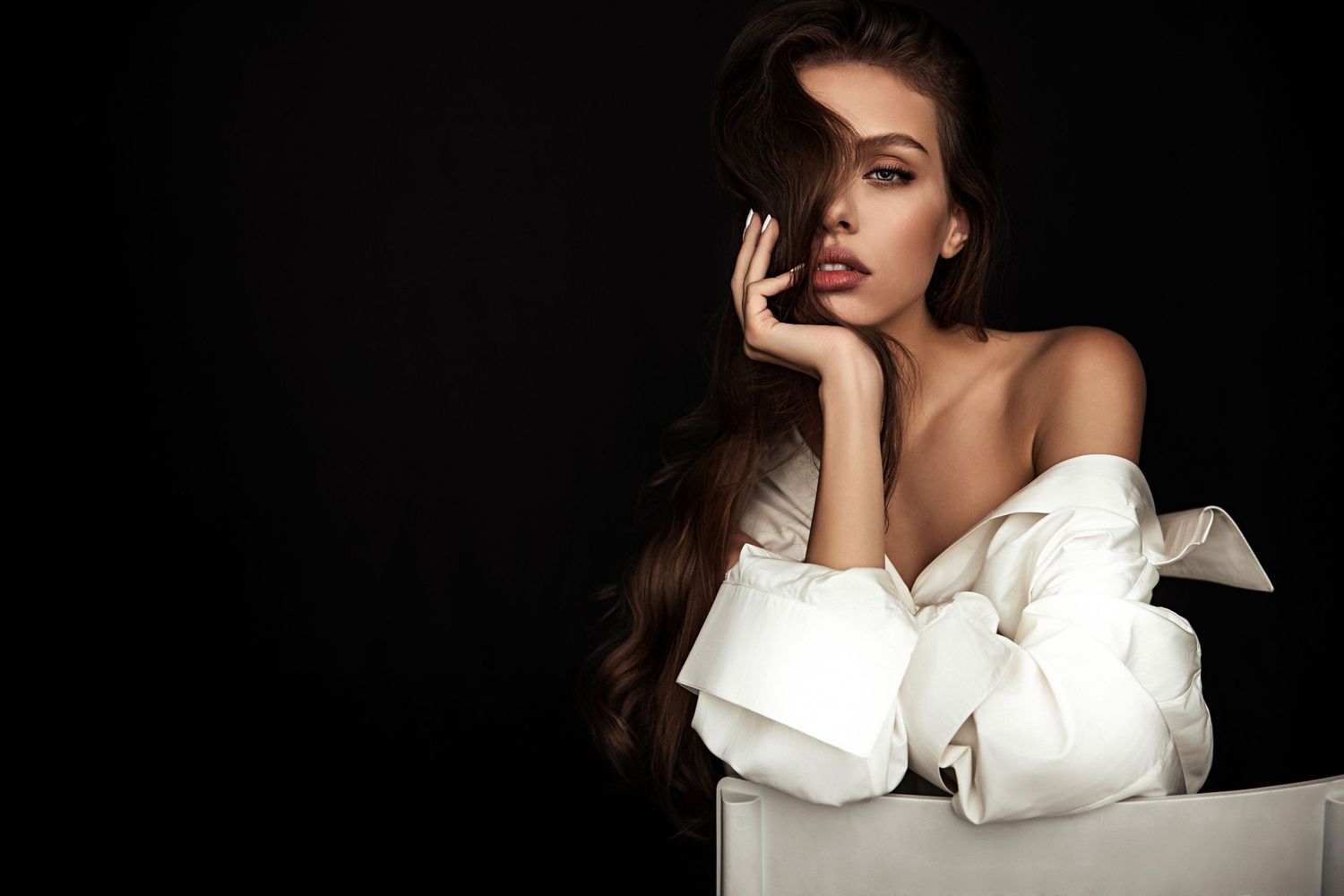 Close-up of a young, beautiful model with green eyes sitting on a chair in man's white shirt by daryanaorange.com.