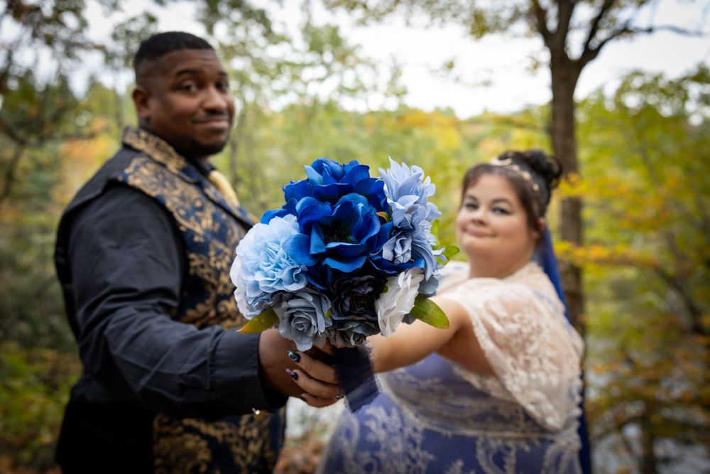 A couple shares a moment with blue floral bouquet during their autumn wedding photoshoot.