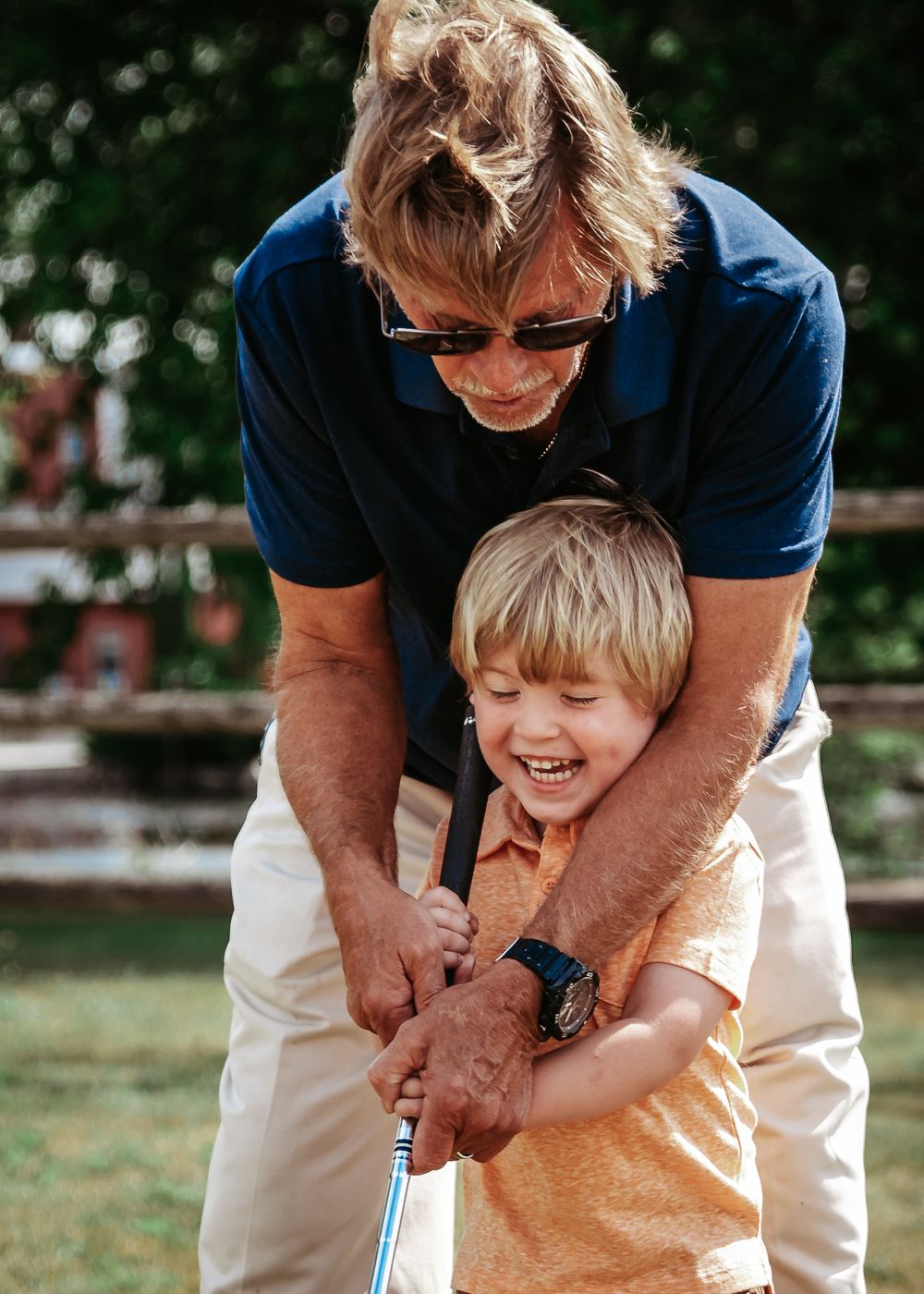A joyful golf lesson moment on a sunny day outdoors.