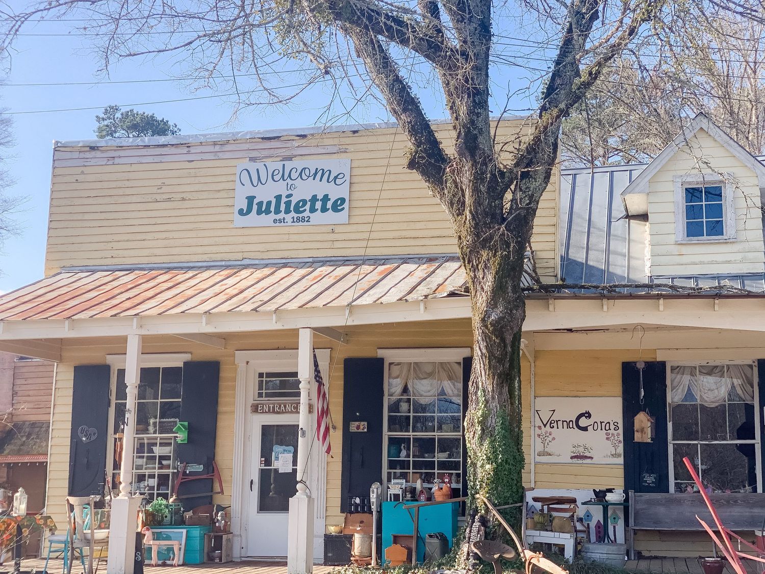 Row of vintage storefronts with wooden porches and classic small-town architecture.