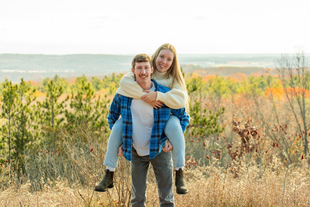 A playful piggyback ride moment captured in a sunny autumn field.
