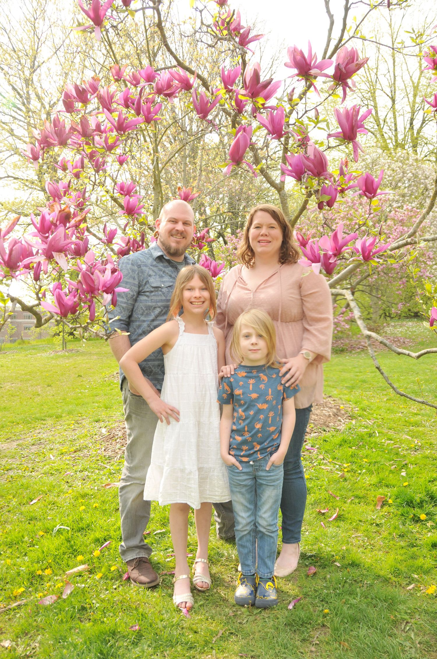 Color photo of family near a magnolia tree