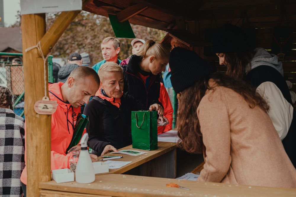 People gather around a rustic wooden table during an indoor social event.
