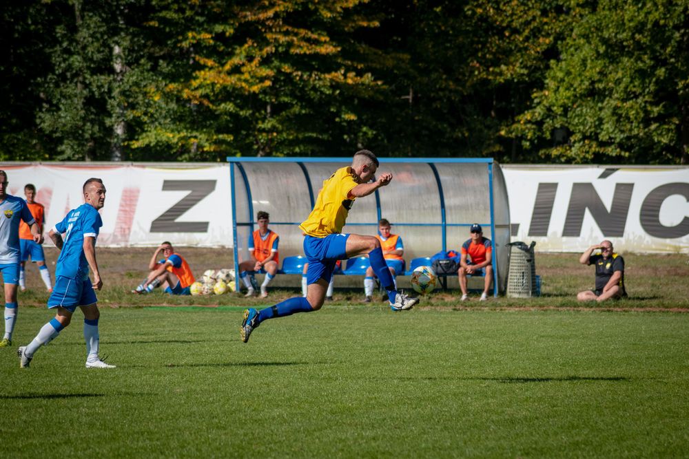 Players in blue jerseys spread across a grass soccer field during a match.