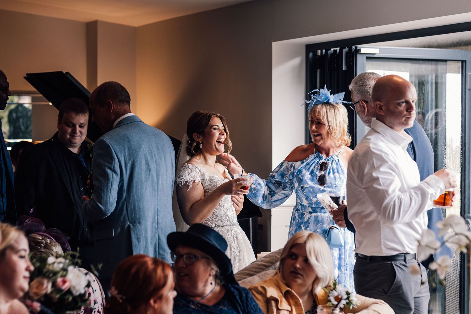 Guests celebrate during indoor wedding reception with warm ambient lighting.