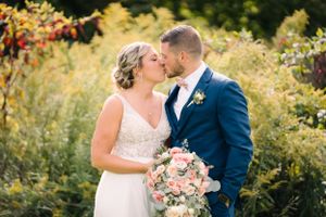 Romantic moment between couple with pink floral bouquet in garden setting.