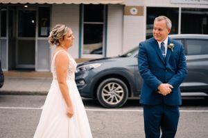 Emotional first look moment between wedding couple in urban setting.