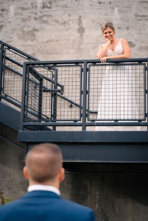 Couple shares romantic moment on industrial staircase during wedding photoshoot.