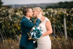 Romantic outdoor wedding portrait with couple sharing intimate moment.