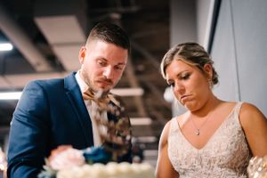 Newlyweds share a sweet moment while cutting their wedding cake together.