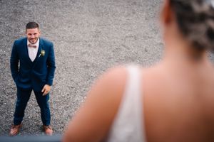 Fun candid reaction during wedding photo session on gravel ground.