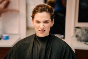 Client in black salon cape during hair appointment.
