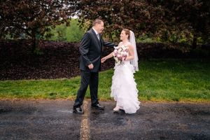 A happy couple shares a moment during their first look on a rainy wedding day.