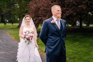 A couple poses during their first look moment on their wedding day outdoors.