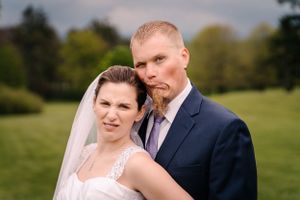 Wedding portrait of couple in formal attire against outdoor natural backdrop.