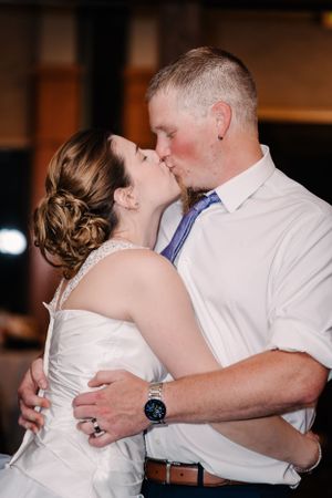 A romantic kiss shared between newlyweds during their wedding reception.